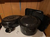 Photo showing entire set including roasting pan with lid, canning pot with wire rack and lid, two drip pans, and funnel.