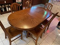 Oval wood dining table with six matching chairs