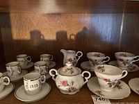 Photo showing the Westville Japan Fine China tea set including creamer, sugar bowl with lid, four teacups and saucers, along with six 25th Anniversary espresso cups and saucers from Japan.