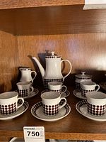 Full view of the vintage Thum espresso set including coffee carafe, creamer, sugar bowl, 6 espresso cups, and saucers arranged on wooden shelf.