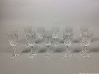 Front view of all (10) Waterford crystal aperitif glasses arranged in two rows showing their cut crystal pattern and stem details.