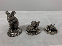 Front view of three sterling silver filled figurines: mouse, two hedgehogs, and squirrel.