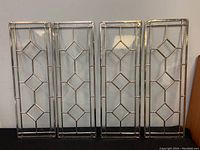 Four vintage leaded glass rectangular panels with diamond pattern, metal came framing and clear textured glass, standing upright against a wall.