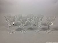 Eight crystal wine glasses arranged in two rows, front view
