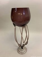 Front and side views showing dark purple blown glass bowl supported by clear glass tentacle shaped loops and circular clear base.