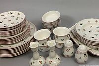 Front-on view of full lot showing stacks of plates, platters, bowls, candleholders, shakers