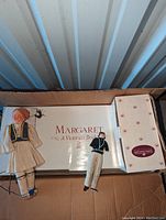 Box containing Margaret A Victorian Bride doll set with bride and groom dolls laid on top