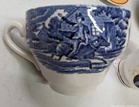 Close-up of a ceramic cup with blue and white historic Paul Revere design of a man on horseback.