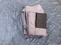 Folded beige canopy side with mesh window on a tarp.