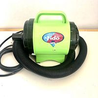 Green Cesar Millan Fido Max 1 B-Air dog dryer unit with black hose on white background.