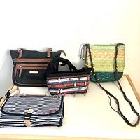 Lot displayed showing all four items: three purses and one folded baby changing pad.
