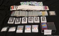 Wide overview of baseball cards collection including various puzzle cards, sticker cards, and mini cards. Multiple rows of cards in protective sleeves and plastic holders visible.