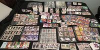 Wide layout showing numerous insert and parallel cards from baseball, hockey and basketball in stacks, sheets, and plastic protectors.
