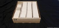 First photo showing one storage box divided into four sections filled with sleeved trading cards.