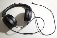 Black Sennheiser HD 400S wired over-ear headphones laid flat showing earcups, padded headband, and attached 3.5mm audio jack cable.