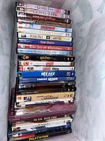 Photo showing a stack of approximately 21 DVDs including religious, animated, holiday, drama, and comedy titles such as The Gospel of John, Chicken Run, Harry Potter, The Black Stallion and Pulp Fiction.