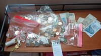 Photo showing assorted foreign coins, collector's coins, and several foreign currency notes.