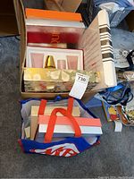 Overhead shot of all boxes and bag on carpet, showing two rows of gift sets and a reusable bag