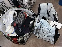 Two large reusable bags filled with various socks, one patterned black-and-white and one Paris-themed