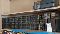 Full shelf showing a large collection of The Harvard Classics volumes and Abraham Lincoln books by Carl Sandburg in black deluxe bindings with gold details.
