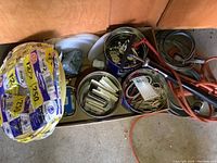 Top view of the lot showing Romex cable rolls on the left, metal tins with outlets and covers in the center, and extension cords on the right side.