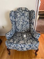 Front-facing view of the Ethan Allen wingback chair showing floral upholstery and curved wooden legs.