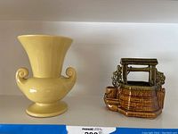 Brown ceramic wishing well planter with roof and flower details, glossy finish