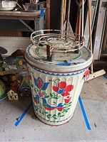 Folk art painted metal trash can with matching lid and floral and bird design
