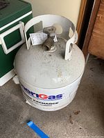 Full view of the white AmeriGas propane cylinder with valve and top guard, showing general condition.