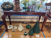 Full view of the wooden side table showing beveled glass top and claw foot legs with decorative carvings