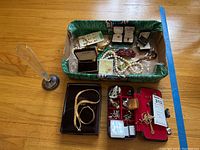 Photo of the lot showing glass vase with sterling base, boxes with bracelets, necklaces, pins, and assorted jewelry in a green box