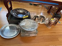 Image showing two Wilton Armetale bowls stacked on boxes, one with an etched floral design and a plain round pewter plate.