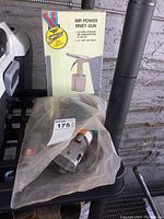 Photo showing Princess Auto Air Power Rivet Gun box and covered tools on black table surface.