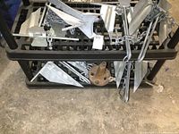 Six galvanized T-shaped fluke anchors with triangular blades and chain on black plastic rack