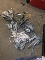 Overview of seven galvanized boat anchors on concrete floor