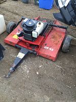Front view of red mower deck with pull-behind hitch tongue