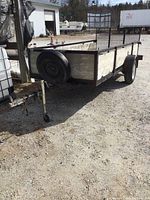 Front-left three-quarter view showing steel frame, wood plank sides, spare tire on front panel