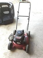 Red White Outdoor gas lawn mower with Honda engine and side discharge chute, shown from front angle.
