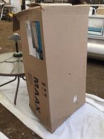 Box of new Maax bathtub, cardboard packaging showing brand and some damage.