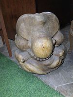 Front view of the solid wood carved statue showing rounded, organic shapes with natural wood grain and a smooth finish.