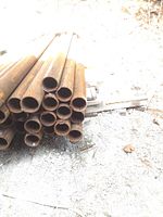 Stack of rusty steel pipes viewed from the side showing pipe length and ends
