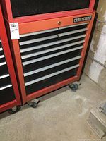 Front view of red Craftsman tool chest showing nine drawers and caster wheels