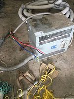 Front and side view of the Bemag transformer showing ventilation slots, attached cable with colored wires, and surface wear.