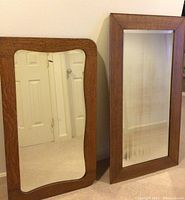 Photo showing two vintage mirrors side by side, one rectangular and one with curved edges, both with wooden frames.