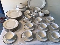 View showing full set of plates, cups and saucers, and serving pieces arranged on table.