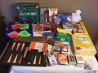 Full view of the collection of games including Outburst, Boggle, Bingo, Backgammon, Quirkle, and other card games.
