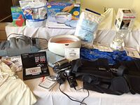 Photo showing overall lot contents including Remington paraffin wax heater, Casio BP100 monitor, heating pad, gloves, cotton balls, and steamer/inhaler