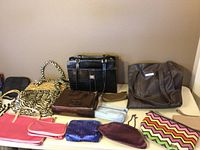 Image showing the entire assortment of purses, clutches, and pouches laid out on a surface.