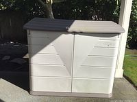 Front view of Rubbermaid outdoor storage container showing double doors and lock hole on lid.