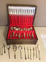 Wooden flatware case open—top row of twelve knives and lower compartments of forks and spoons